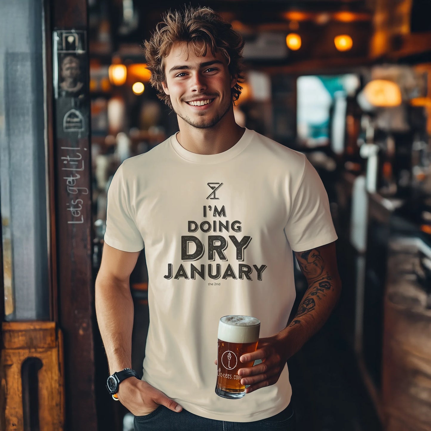 Man holding a beer in a bar wearing a 'I'm Doing Dry January' t-shirt.