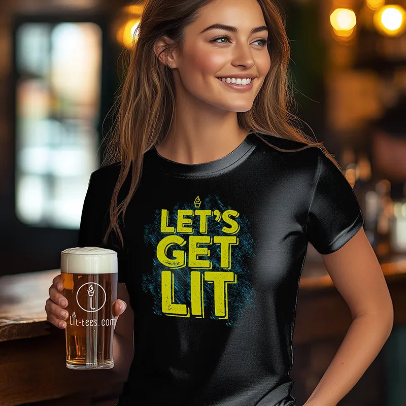 Woman standing in bar holding a beer wearing black 'Let's get Lit' Tee Shirt