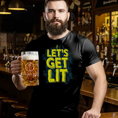 Man standing in bar holding a beer wearing black 'Let's get Lit' Tee Shirt