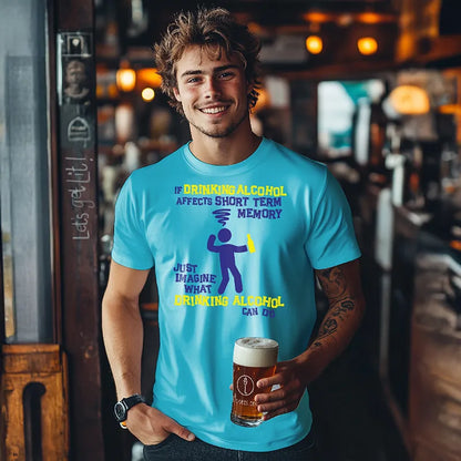 Man holding a beer in a bar wearing a blue tee shirt with a graphic character and humorous text saying 'If drinking alcohol affects short term memory just imagine what drinking alcohol can do' 