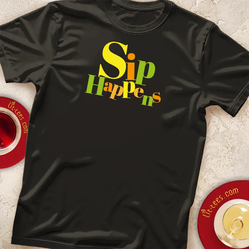 Black t-shirt with 'Sip Happens' text in colorful letters on a textured surface.