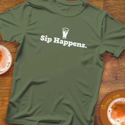 Military Green t-shirt with 'Sip Happens.' text on a wooden surface with drinks.