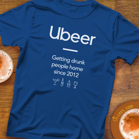 Blue t-shirt with 'Ubeer' text and graphics on a wooden surface with drinks.